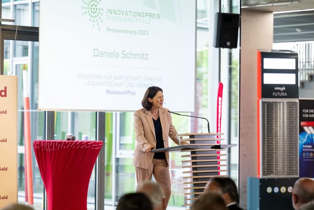 Nainen pitää puheen Rheinland-Pfalzin innovaatiopalkinnossa 2023