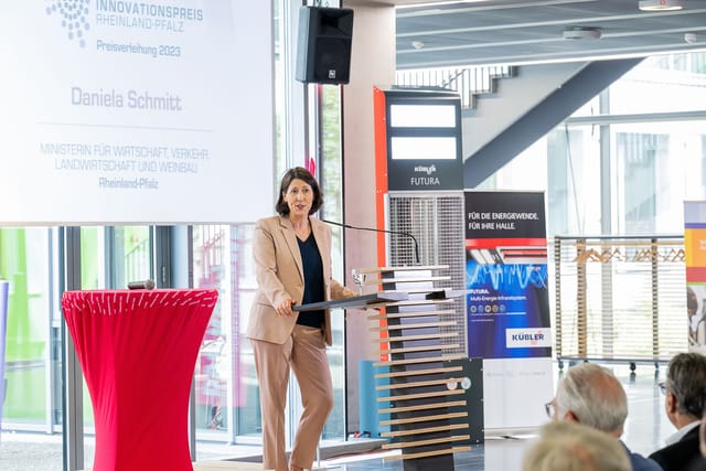 Nainen pitää puheen Rheinland-Pfalzin innovaatiopalkinnossa 2023