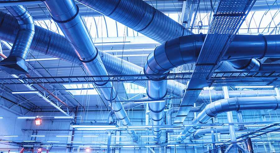 Industrielle ventilasjonskanaler i en fabrikkbygning.