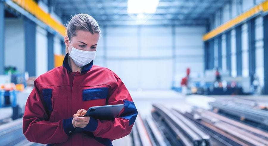 Engineer with tablet on the factory floor.