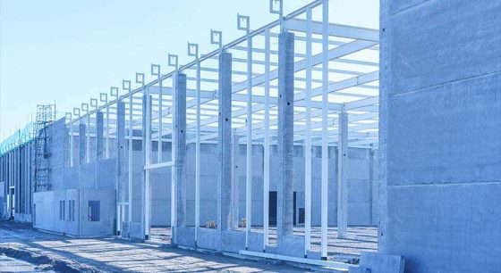 Betonkonstruktion af en industrihal under opførelse.