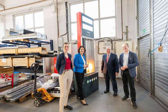 Daniela Schmitt in the KÜBLER production hall with three other people in front of the FUTURA model