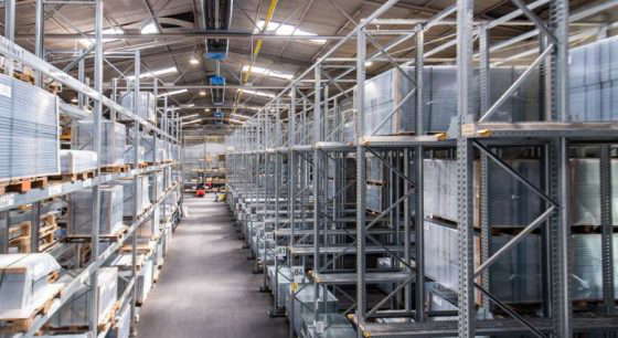 Склад со стеллажами и вилочным погрузчиком.