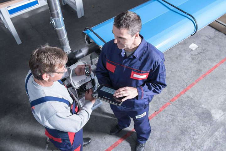 Zwei Mitarbeiter stehen sich gegenüber und besprechen ihre Arbeit.