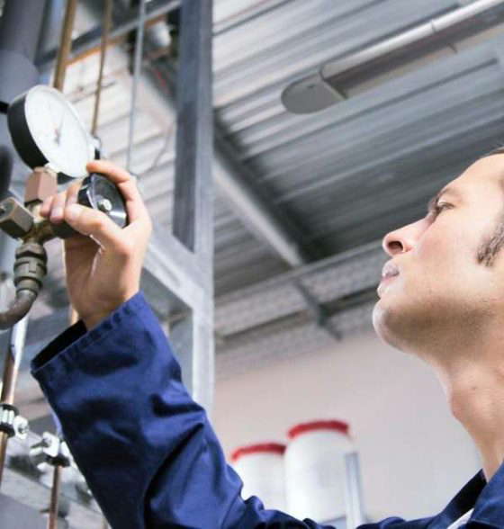 Techniker prüft Industrieanlage Manometer.