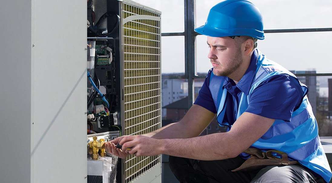 Arbeiter in blauer Schutzkleidung arbeitet an KÜBLERs SmartHeat Wärmepumpe