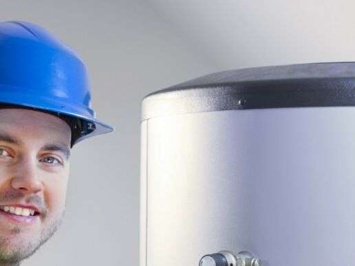 Mitarbeiter mit Schutzhelm und Sicherheitsweste an einem Tank