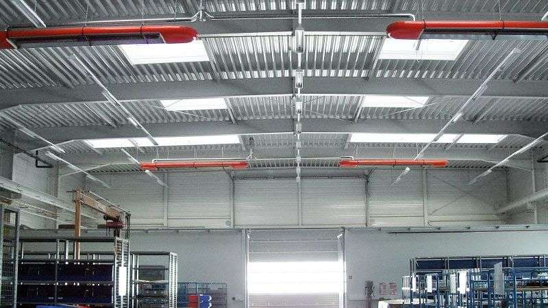 Leerstehendes Hochregallager mit geschlossenem Hallentor, ausgestattet mit dem OPTIMA plus Dunkelstrahler von KÜBLER in roter Farbe