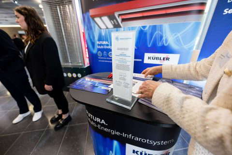Exhibition stand with people and information material.
