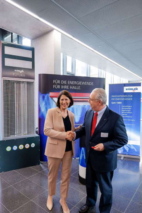 Business people shaking hands next to an energy transition poster.
