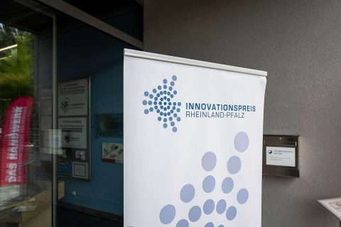 INNOVATIONSPREIS RHEINLAND-PFALZ" banner at the entrance to the building.