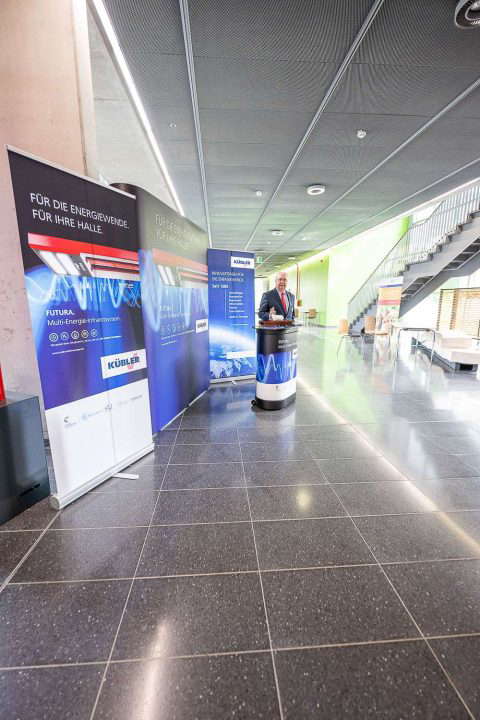 Exhibition stand with information banners and visitors.