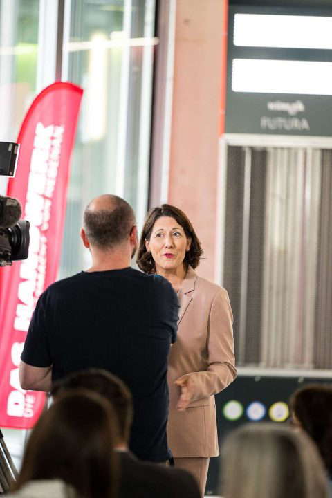 Woman speaks at event with microphone.