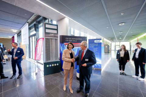 People at a trade fair with exhibition stands.