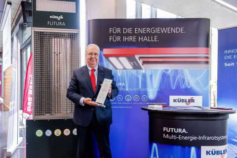 Mr. presents award at trade fair stand.