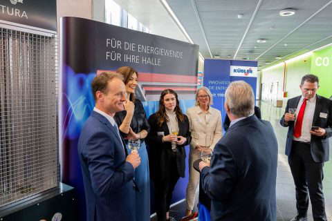 Business people at a trade fair stand with drinks.