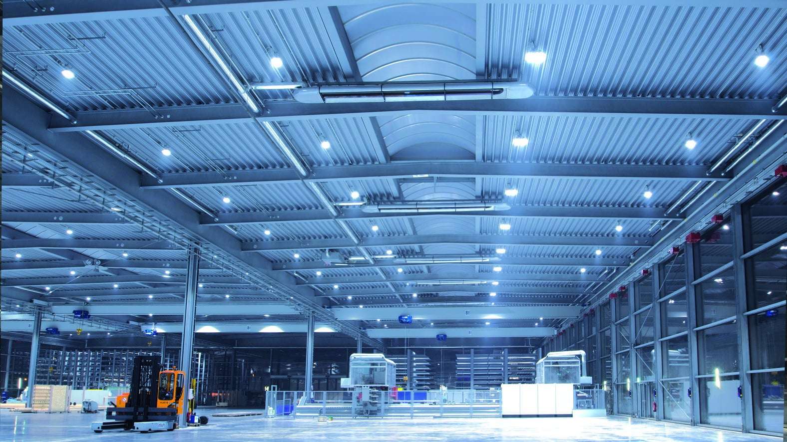 Logistiksal badet i blåt lys med reflekterende gulve, OPTIMA plus mørke spotlights fra KÜBLER i loftet i samme farve som salen.