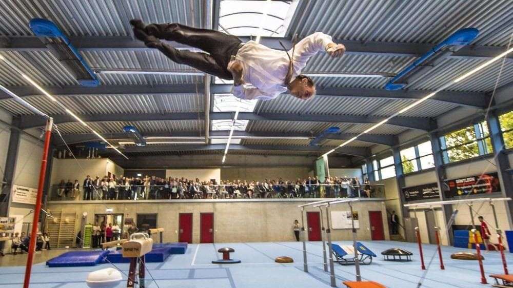 Turner beim Salto vor Publikum.