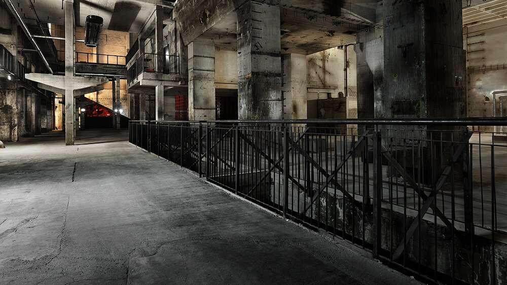 Industrielle Halle mit Betonstruktur und Geländer.