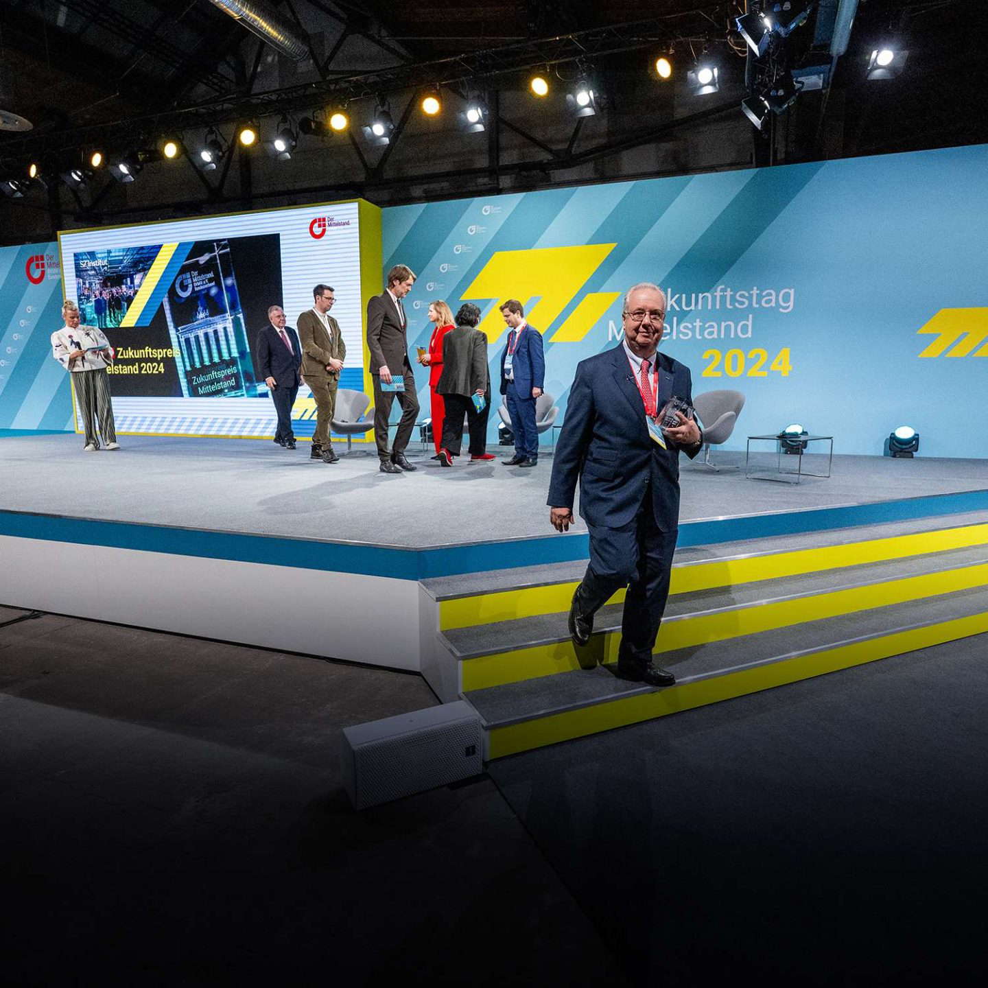 Emberek egy üzleti konferencia színpadán.