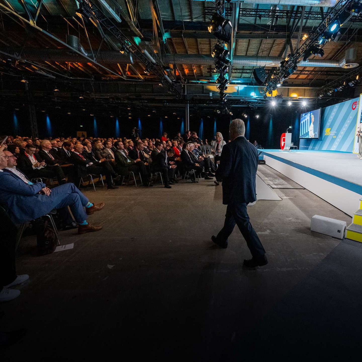 Előadó a színpadon egy konferencia közönsége előtt
