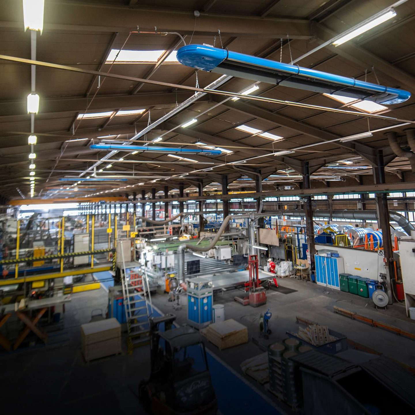 Teollisuushalli, jossa on koneita ja valaistus
