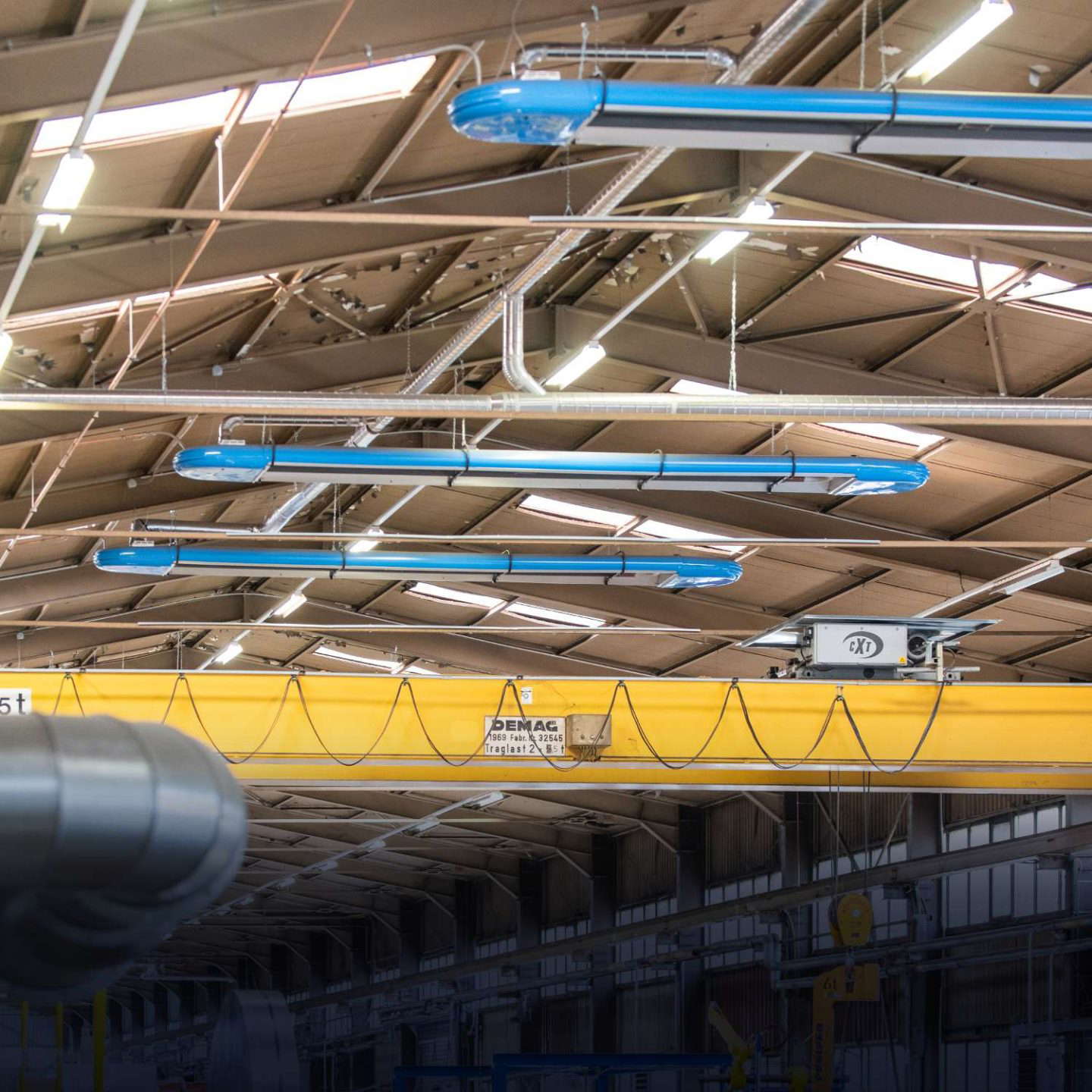 Teollisuushalli nosturilla ja valaistuksella.