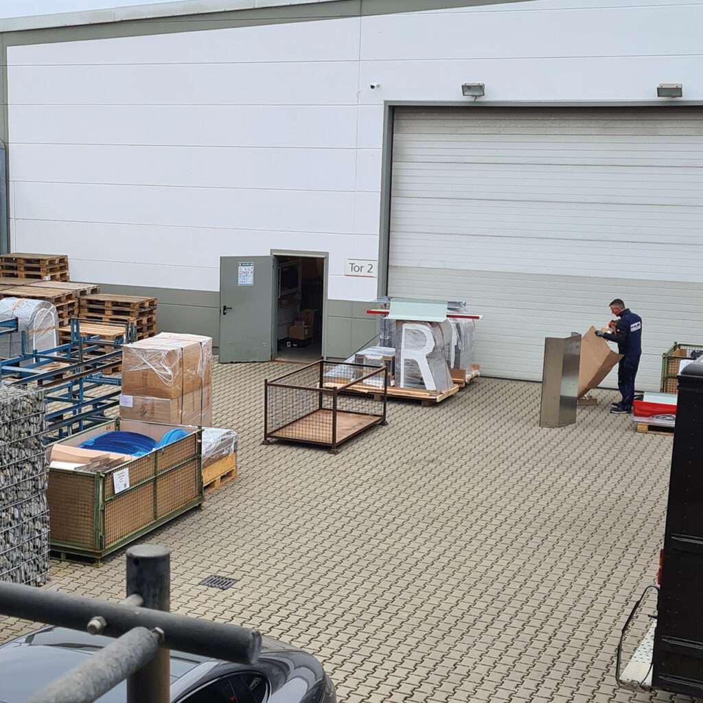 Работник склада во время погрузочных работ на открытой площадке.