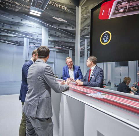 Деловые люди беседуют у выставочного стенда.