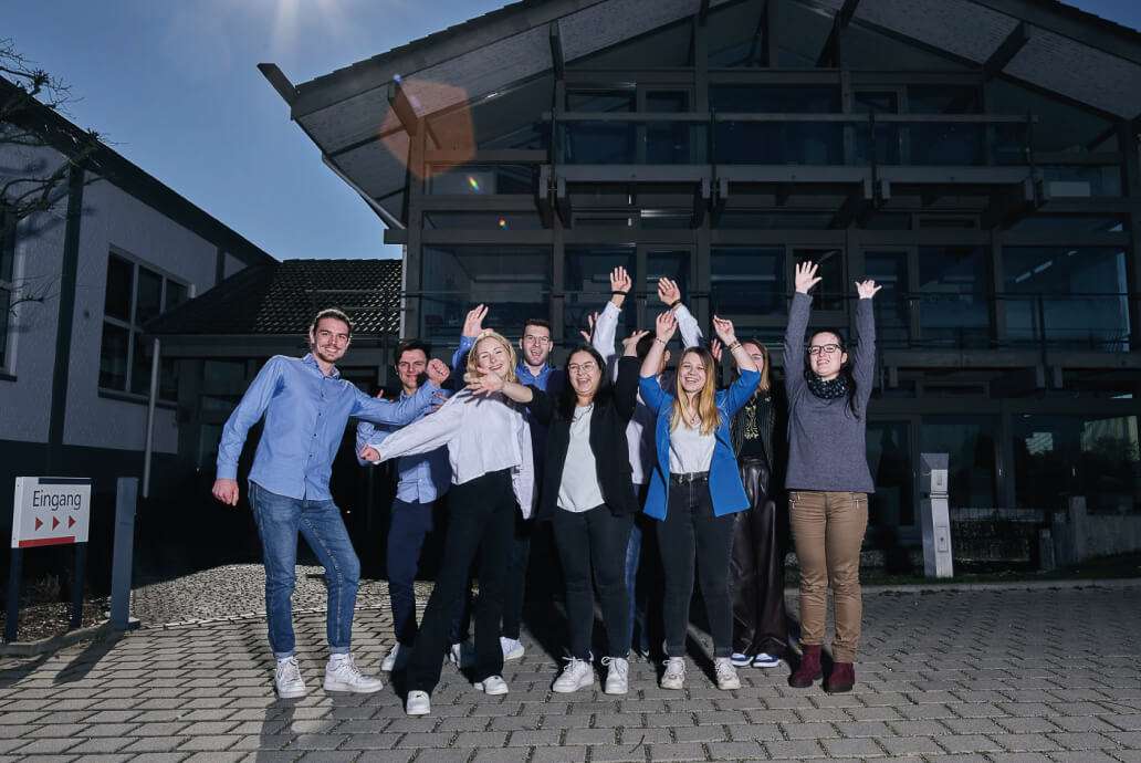 Group of cheering employees in front of office building