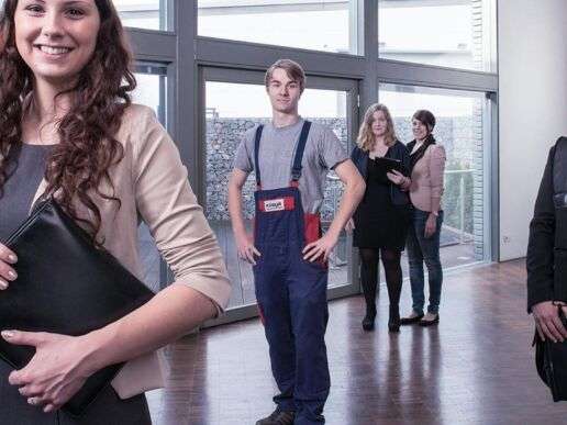 Фотография для раздела "Карьера" на домашней странице KÜBLER: сотрудники офиса и склада стоят в приемной и приветливо смотрят на зрителя