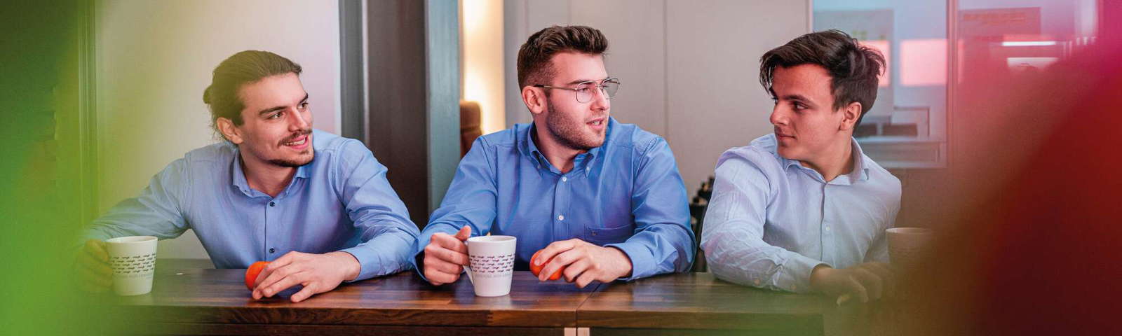 Drei Kollegen im Gespräch bei Kaffeepause.