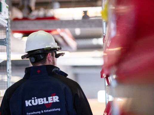 Ingenieur im Lager mit Schutzhelm und Arbeitsjacke