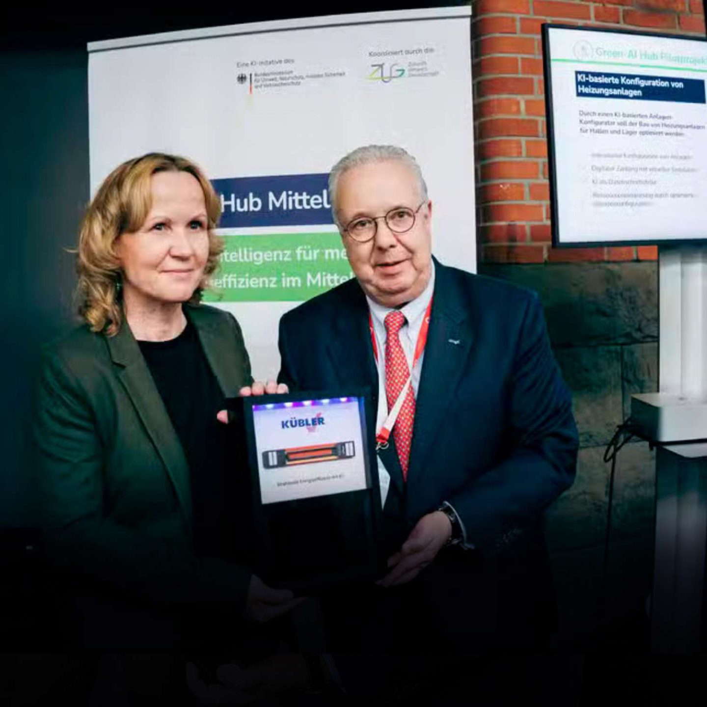 Two people present a digital award.