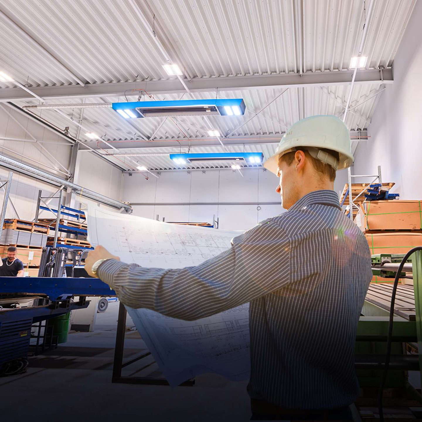 Ingeniøren ser på byggeplanen i verkstedet.