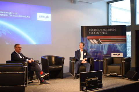 Zwei Männer sprechen bei einer Konferenz über Energie