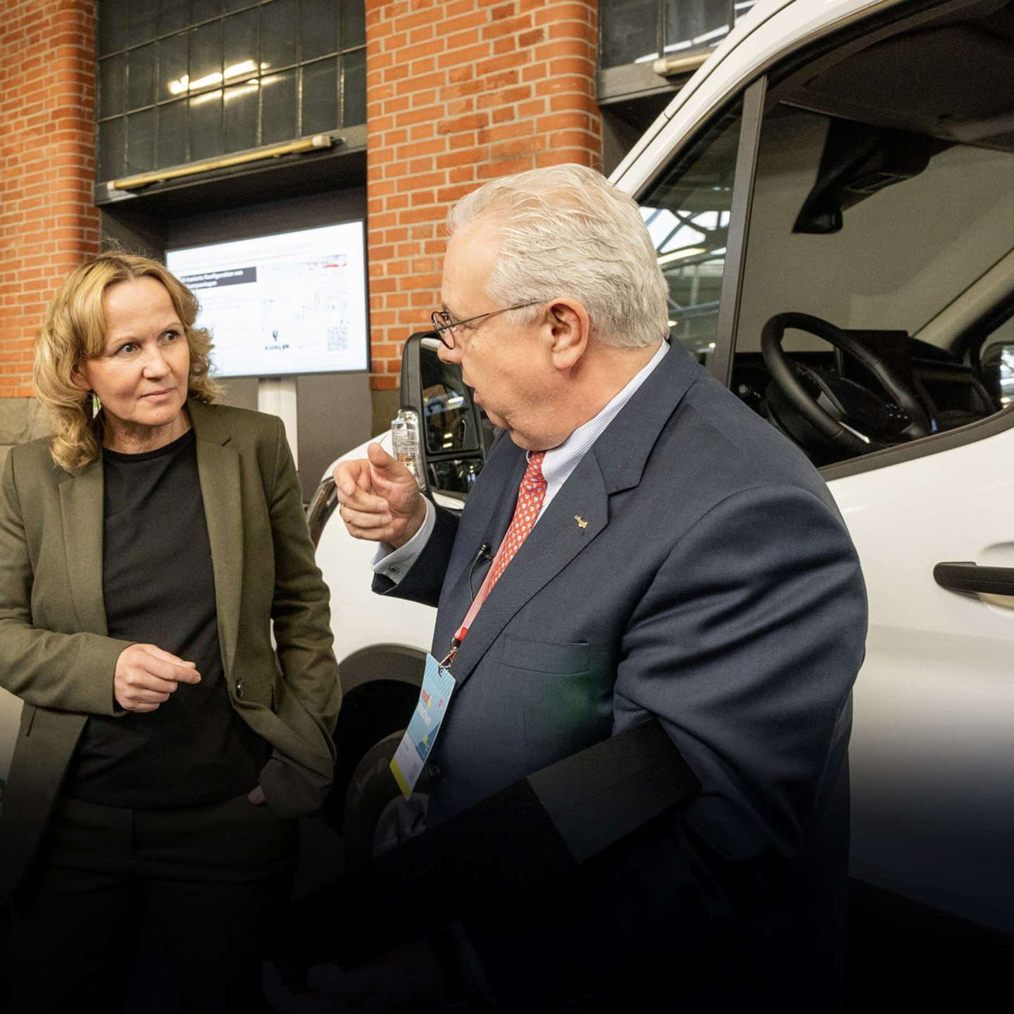 Man and woman discussing next to car.