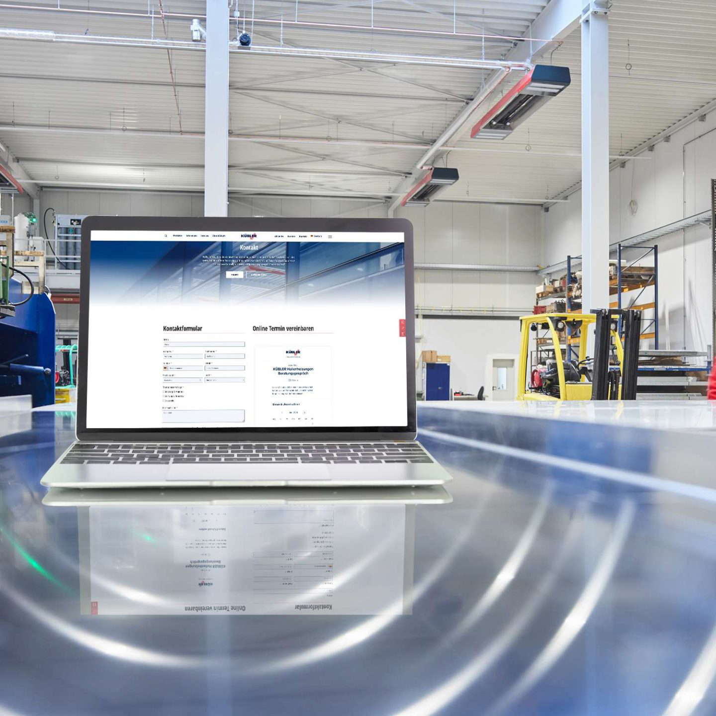 Laptop egy weboldallal egy ipari csarnokban.