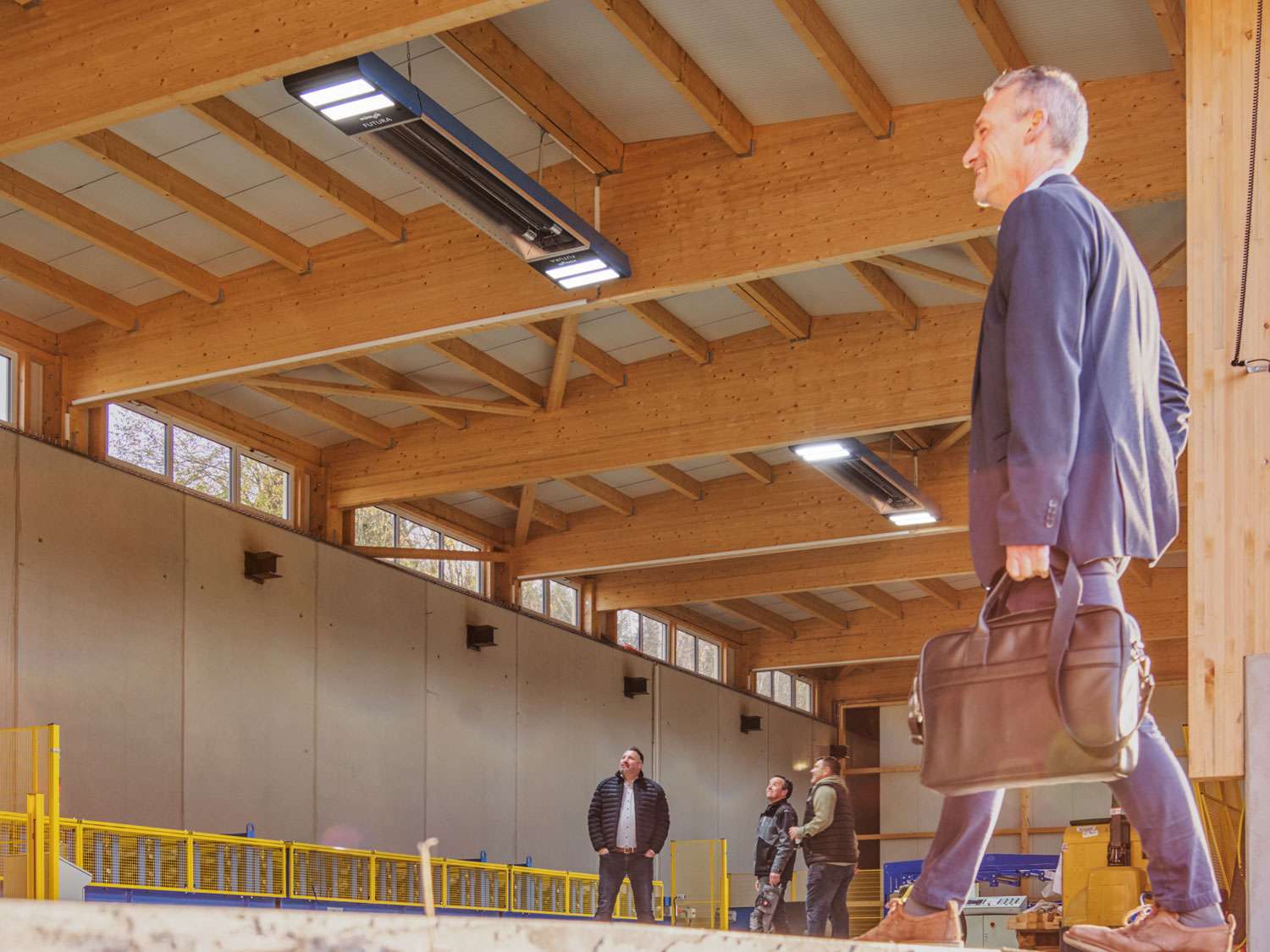 Mann geht in einer modernen Holzwerkstatt