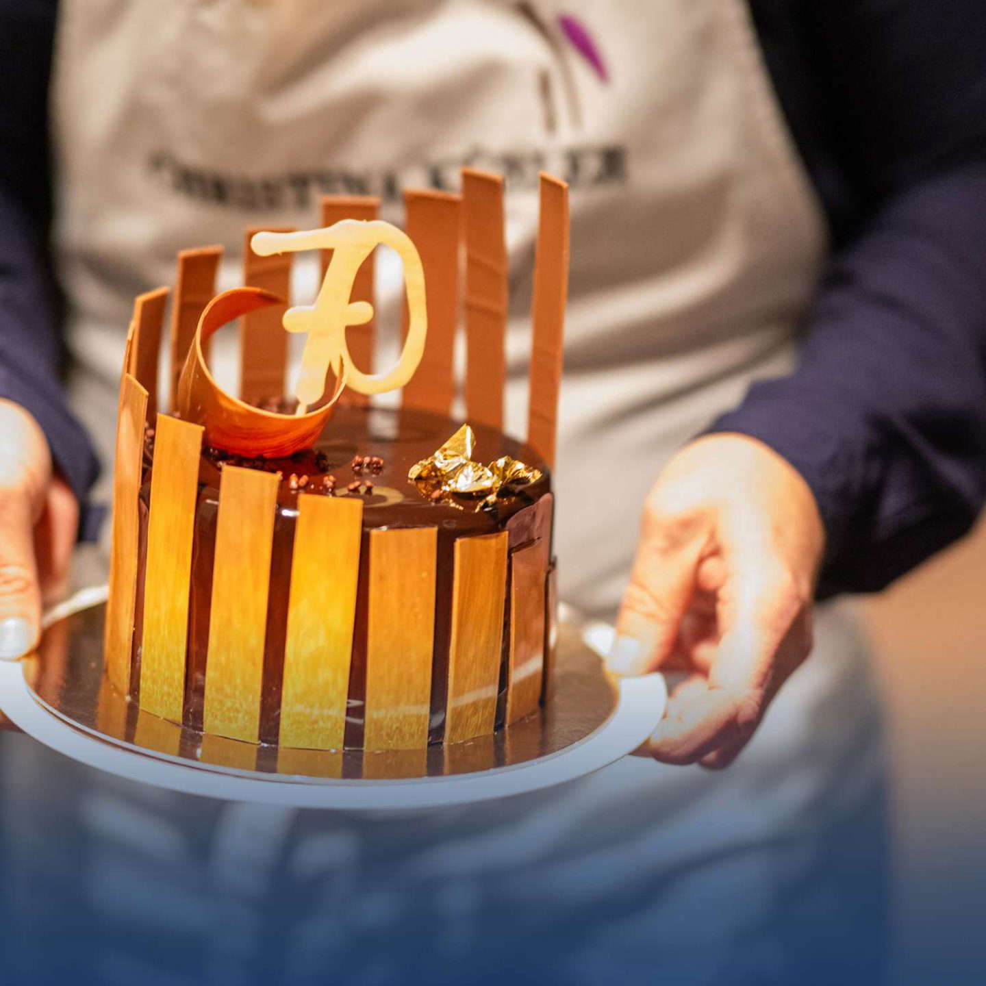 30-as számmal ellátott luxus tortát tartó személy