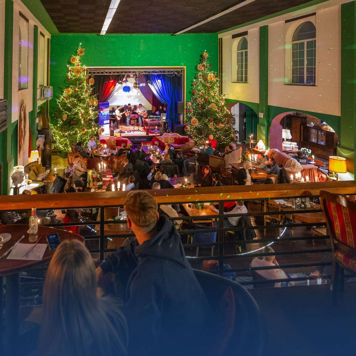 Joulumarkkinat sisätiloissa lavalla ja ihmisiä