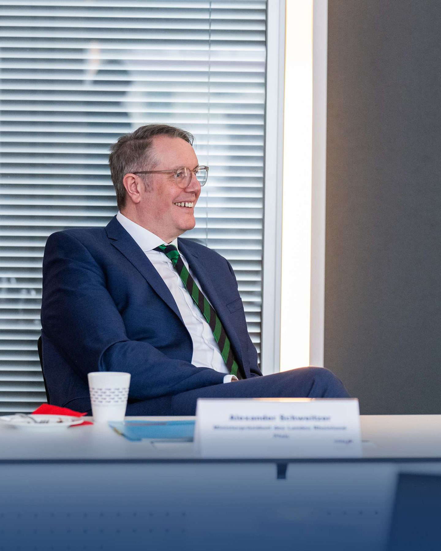 Lächelnder Geschäftsmann sitzt bei Besprechung