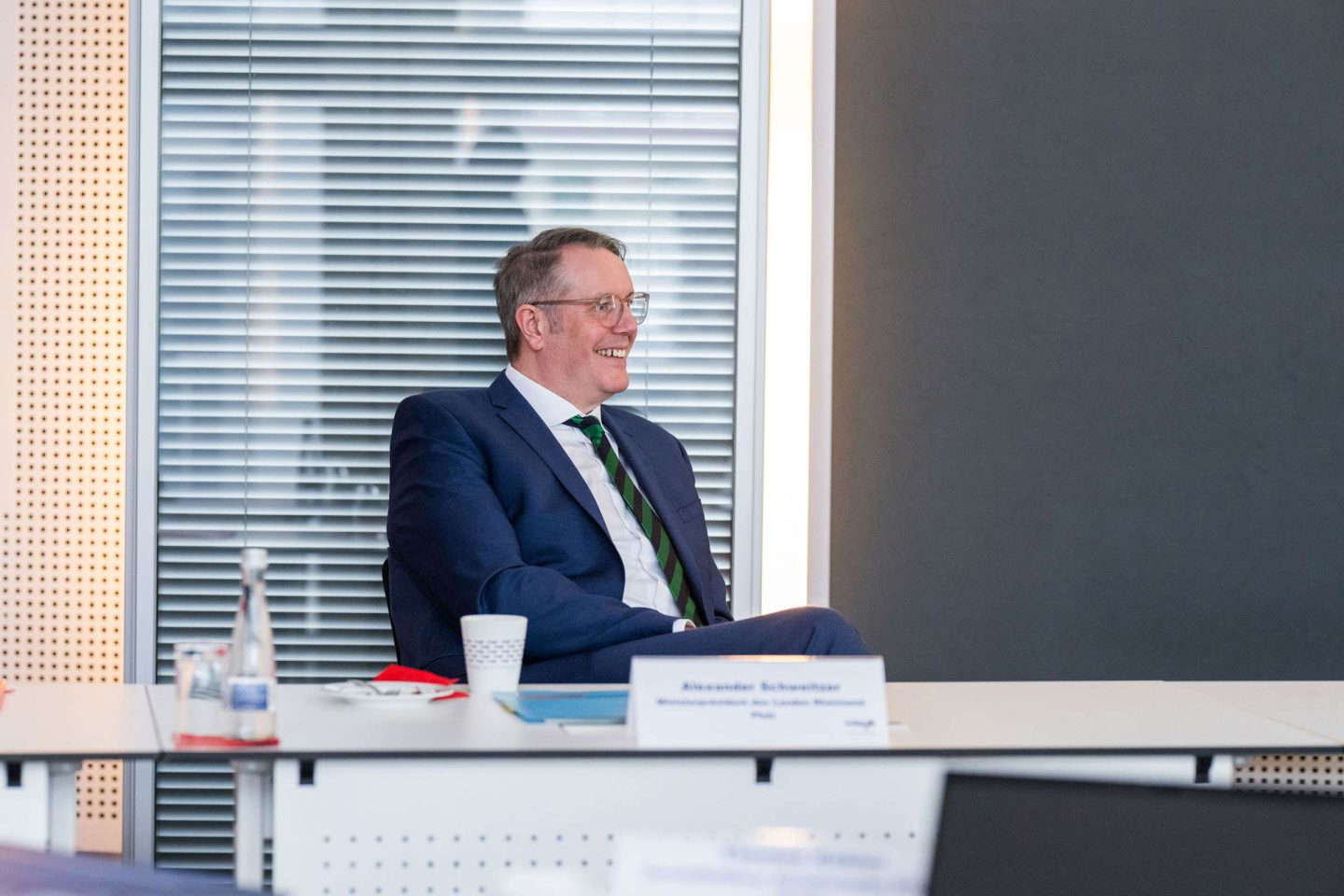 Lächelnder Mann sitzt bei einer Konferenz