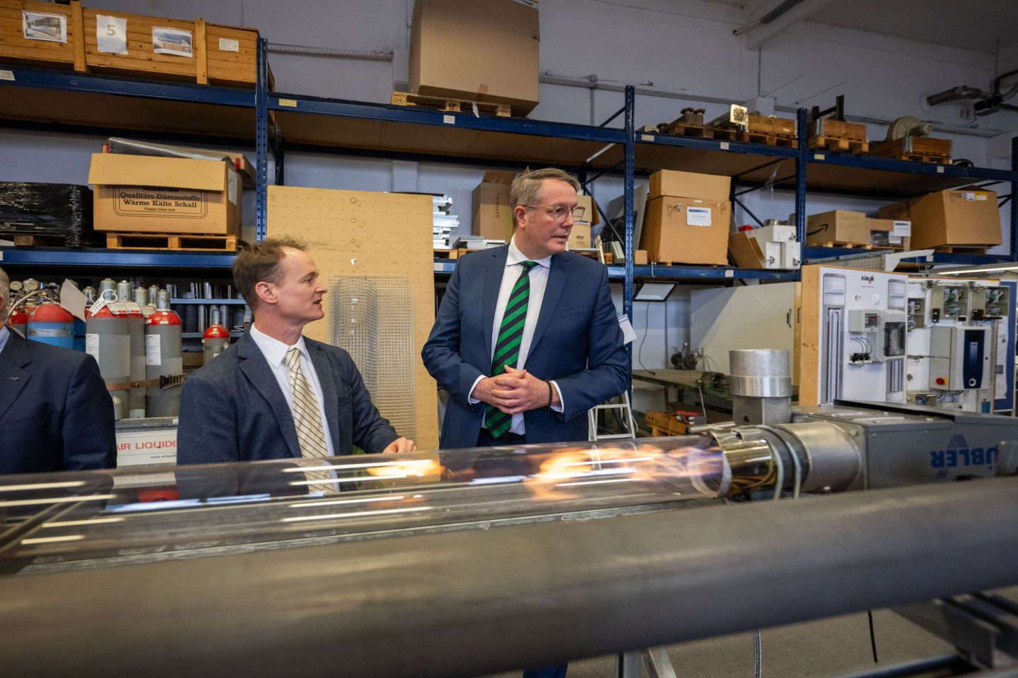 Zwei Männer betrachten Laborausrüstung in Lagerhalle.