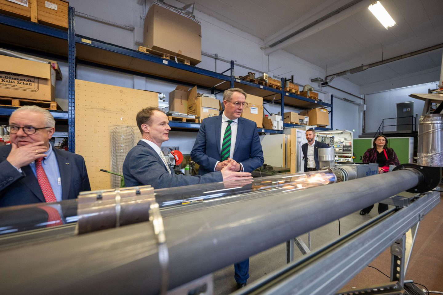 Führungskräfte beobachten technische Vorführung in Werkstatt