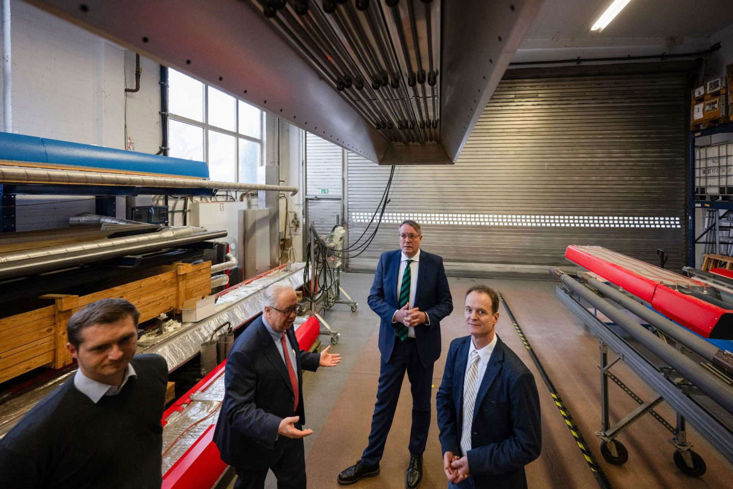 Männer diskutieren in industrieller Werkstatt