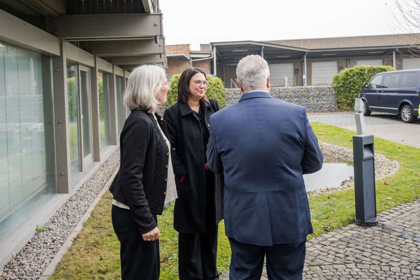 Drei Personen unterhalten sich draußen