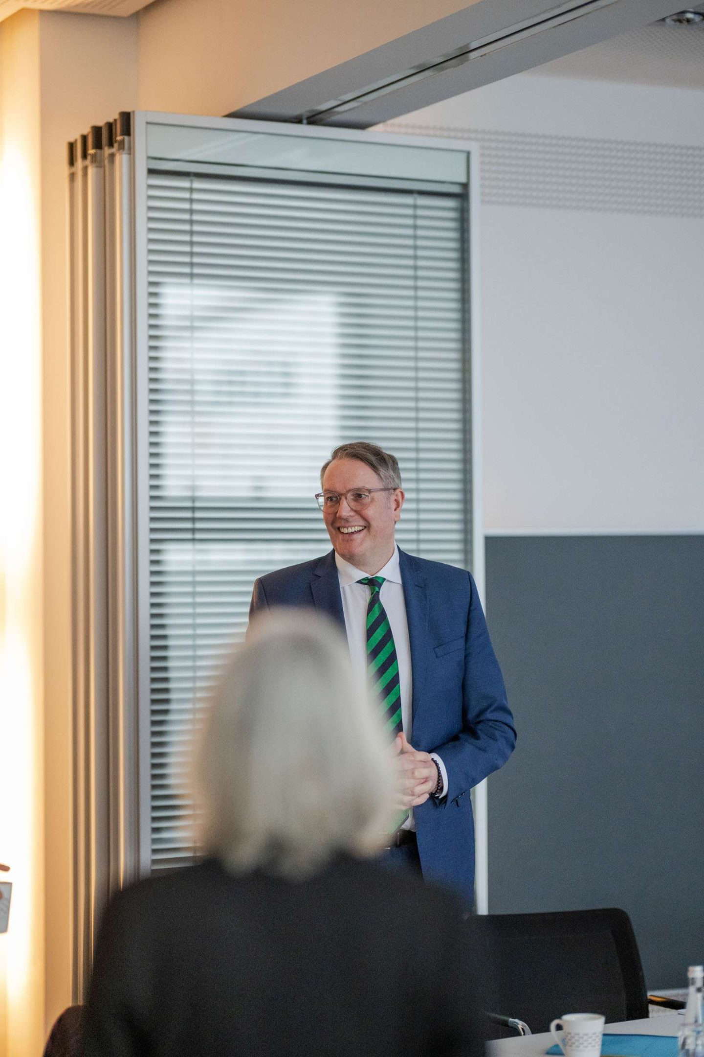 Mann präsentiert lächelnd in Büroumgebung