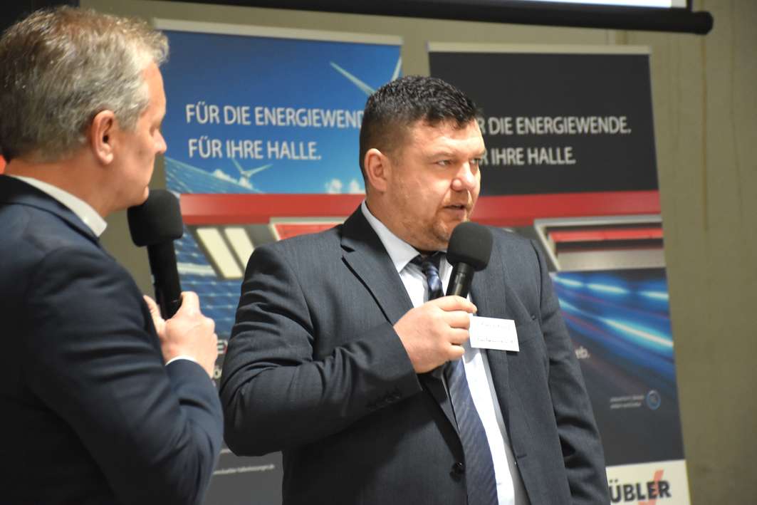 To mænd diskuterer med mikrofoner på en konference