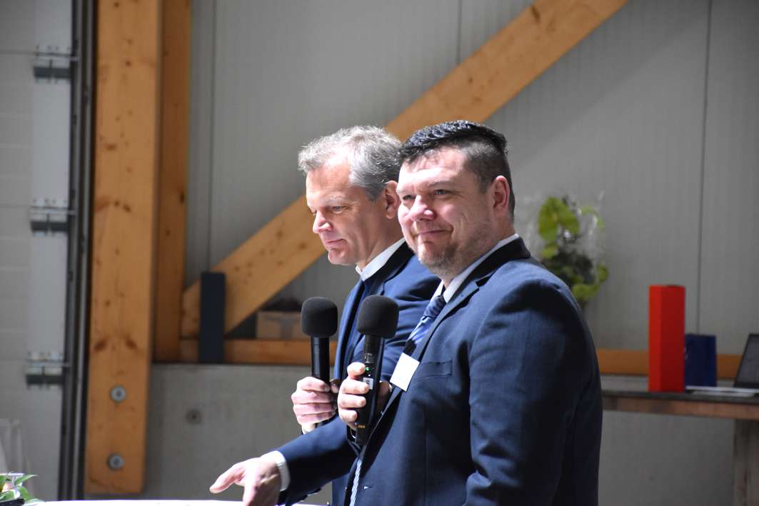 To mænd holder taler ved arrangement